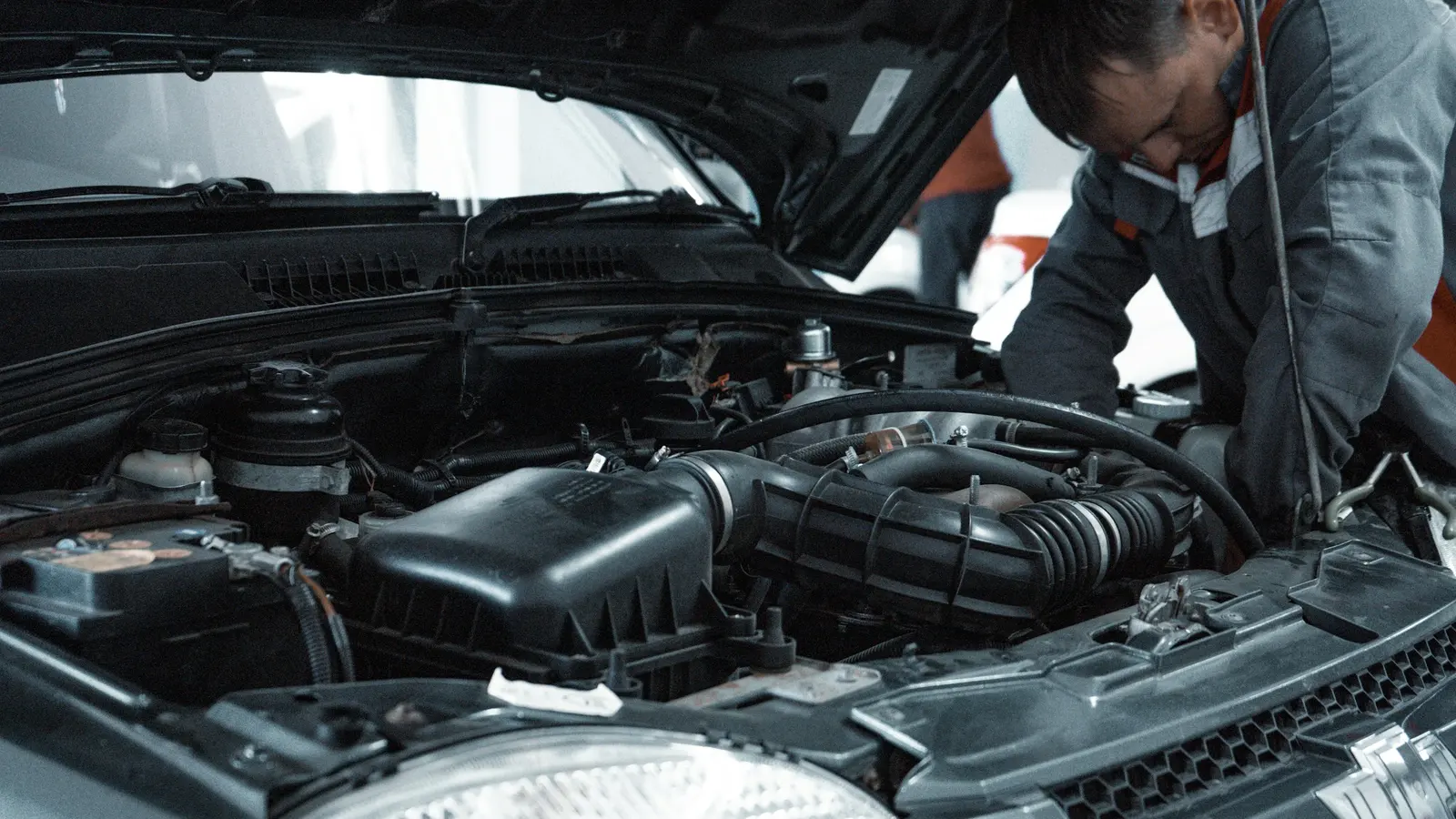 Mecánico trabajando en el motor de un vehículo en un taller de Pucón. Imagen de referencia.